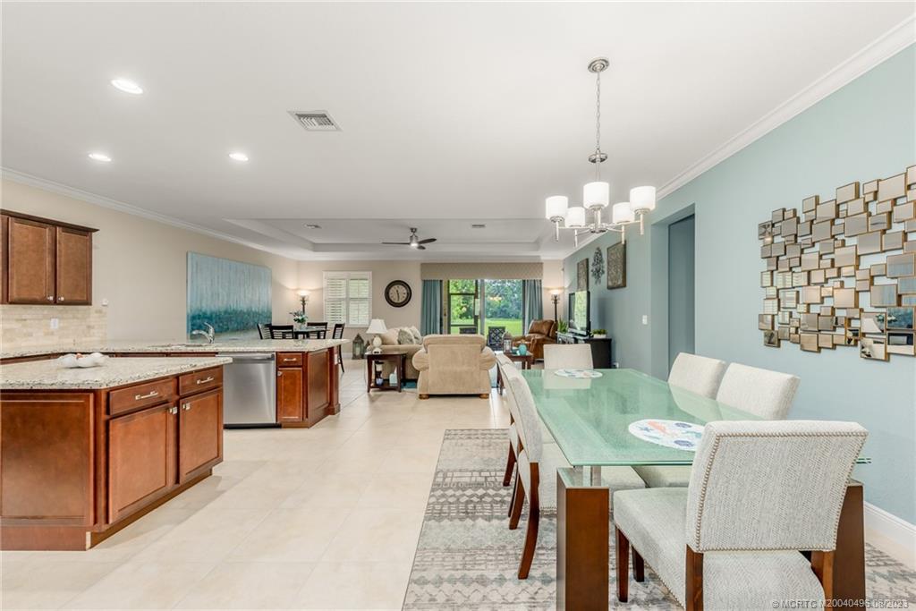 5891 Southeast Entry Court Stuart, FL 34997 - Photo 4 of 29 a view of a dining room and livingroom with furniture wooden floor a chandelier