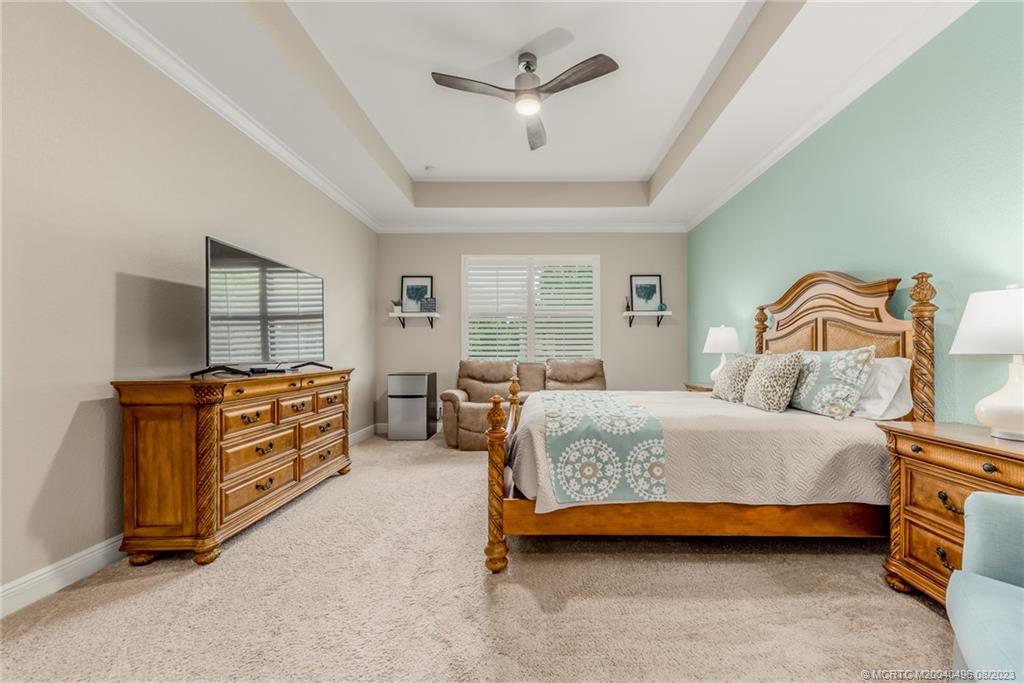 5891 Southeast Entry Court Stuart, FL 34997 - Photo 9 of 29 a bedroom with a bed and large windows