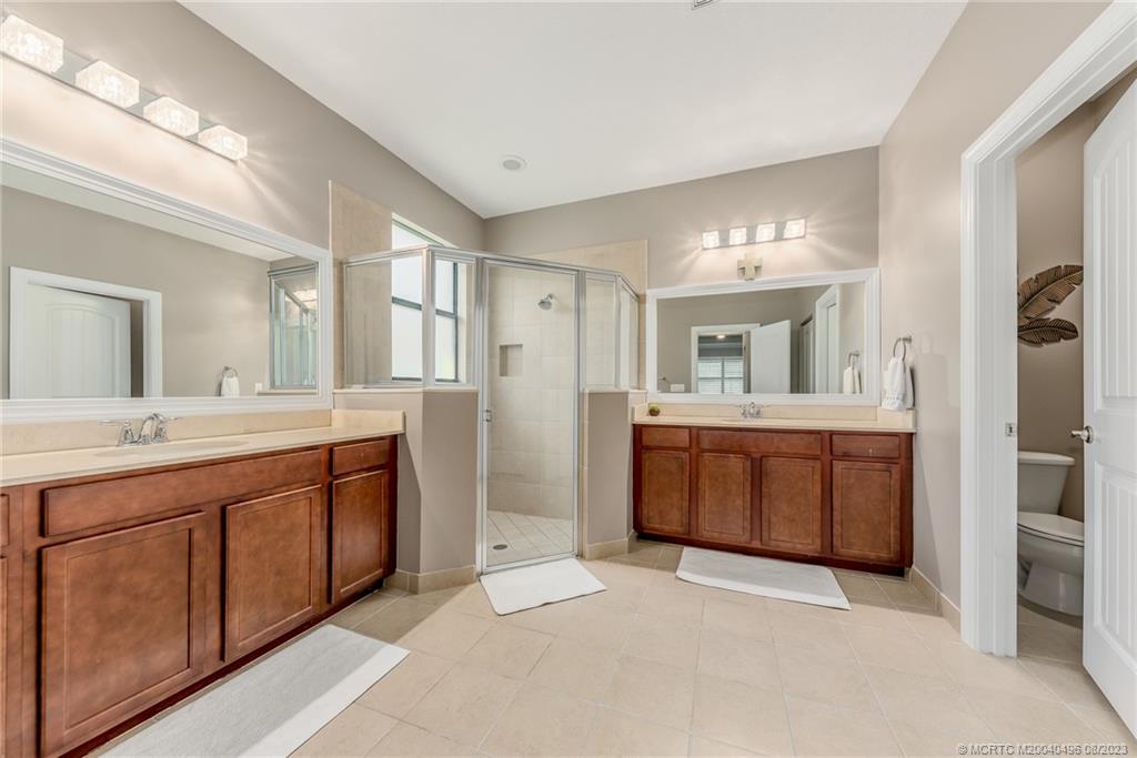 5891 Southeast Entry Court Stuart, FL 34997 - Photo 10 of 29 a spacious bathroom with a granite countertop sink and mirror