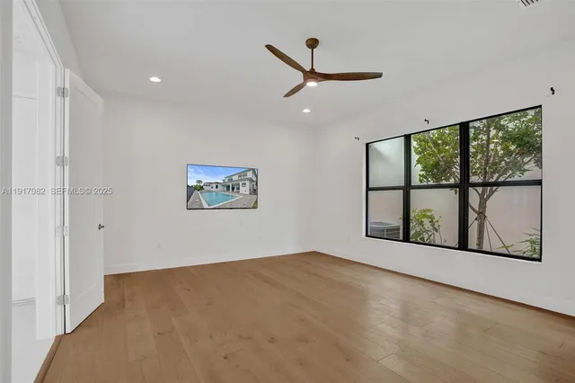 an empty room with windows and fan