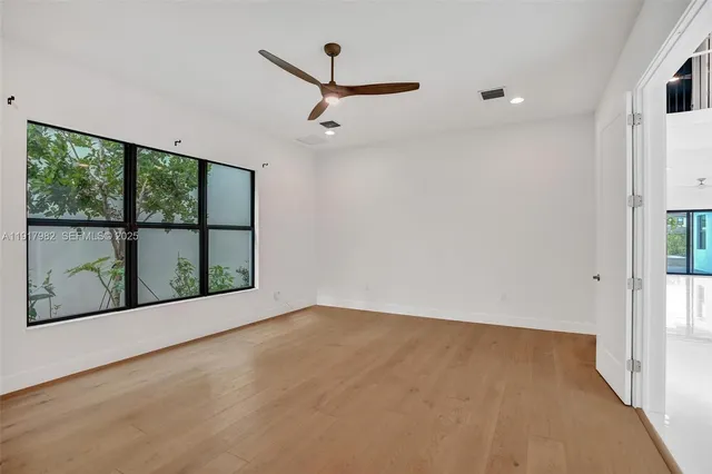 a view of empty room with wooden floor