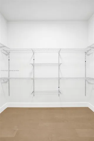 a room with lots of tables a large window and furniture