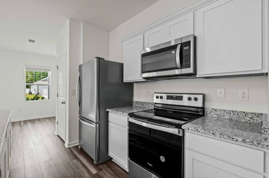 18200 Papuan Cove Elgin, TX 78621 - Photo 6 of 21 a kitchen with a stove microwave and refrigerator