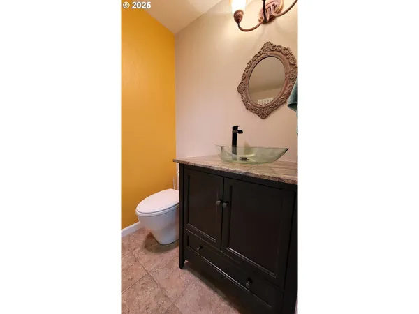 a bathroom with a granite countertop toilet sink and mirror