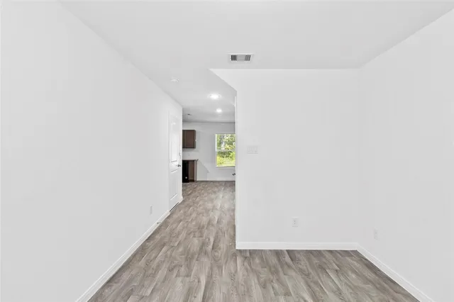 a view of a hallway with wooden floor