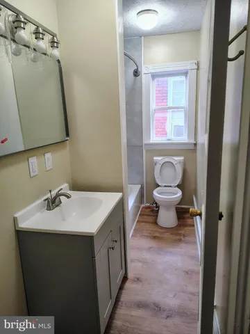 a bathroom with a sink mirror vanity and toilet