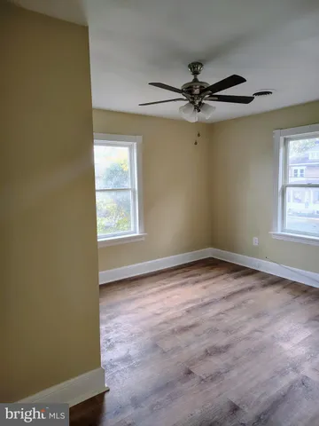 an empty room with windows and fan