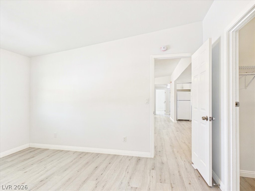 4081 Retread Road Pahrump, NV 89048 - Photo 30 of 98 Bright, unadorned room with light wood-look flooring connects to a well-appointed kitchen.