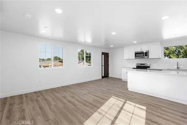 a view of kitchen with microwave and white cabinets