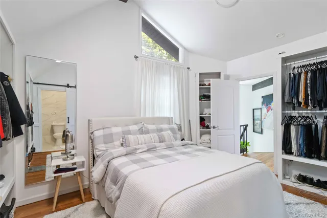 a bedroom with a bed and a flat tv screen on the dresser