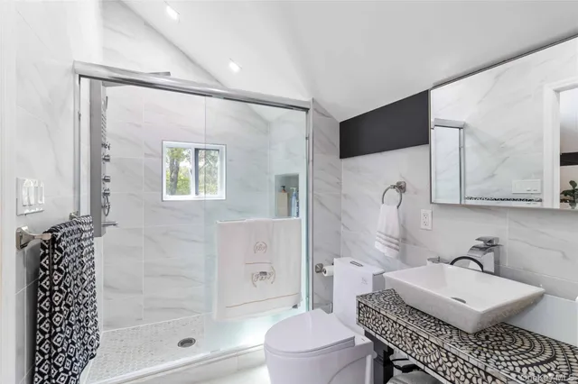 a bathroom with a sink toilet a mirror and shower