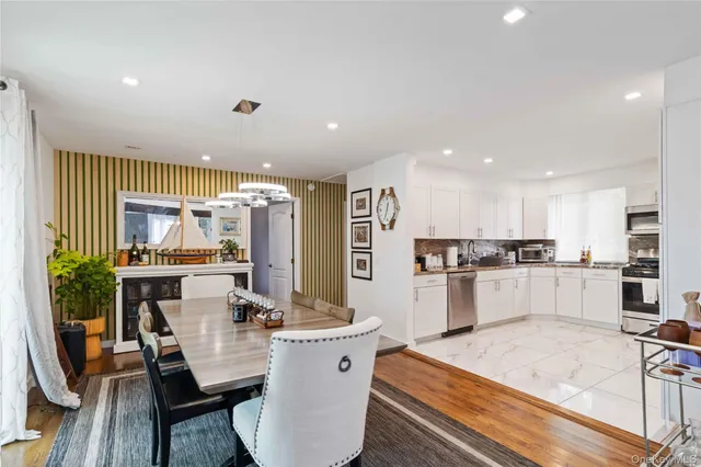 a large kitchen with kitchen island a sink a stove a dining table and chairs