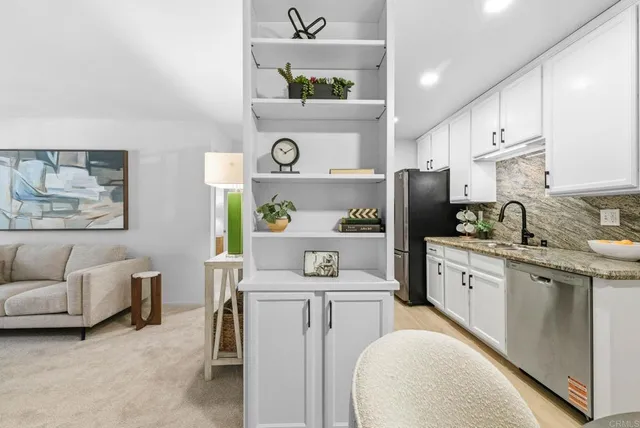 a kitchen with stainless steel appliances cabinets and a couch