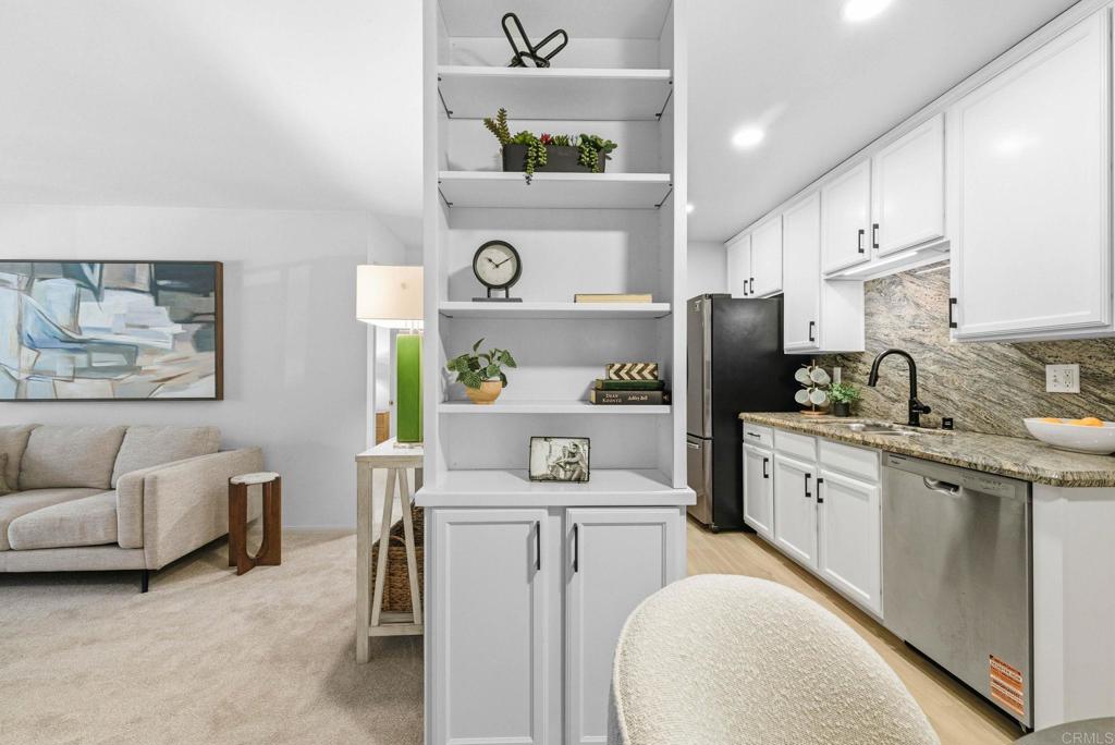 1750 South El Camino Real, Unit 211 Encinitas, CA 92024 - Photo 14 of 44 a kitchen with stainless steel appliances cabinets and a couch
