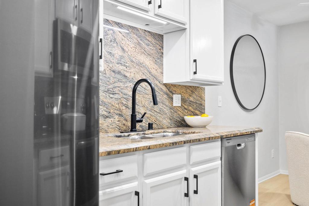 1750 South El Camino Real, Unit 211 Encinitas, CA 92024 - Photo 20 of 44 a bathroom with a granite countertop sink a mirror and a shower