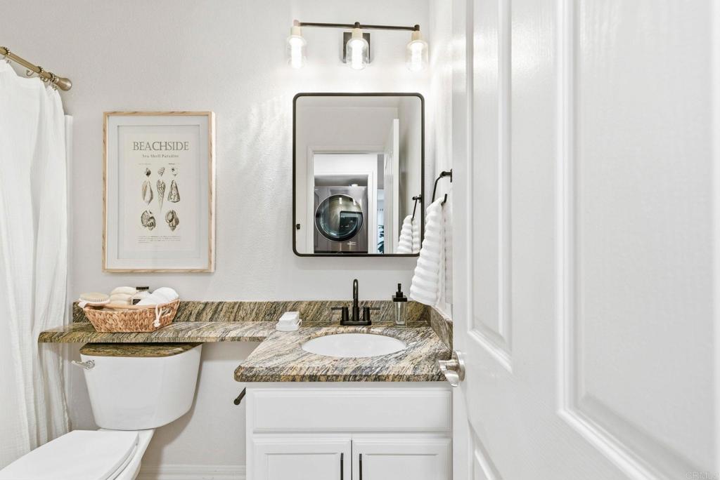 1750 South El Camino Real, Unit 211 Encinitas, CA 92024 - Photo 29 of 44 a bathroom with a granite countertop sink and a mirror