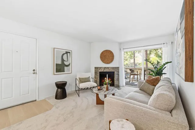 a living room with furniture a fireplace and a large window