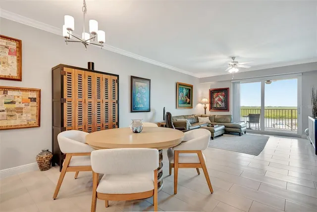 a view of a dining room with furniture a chandelier and a large window