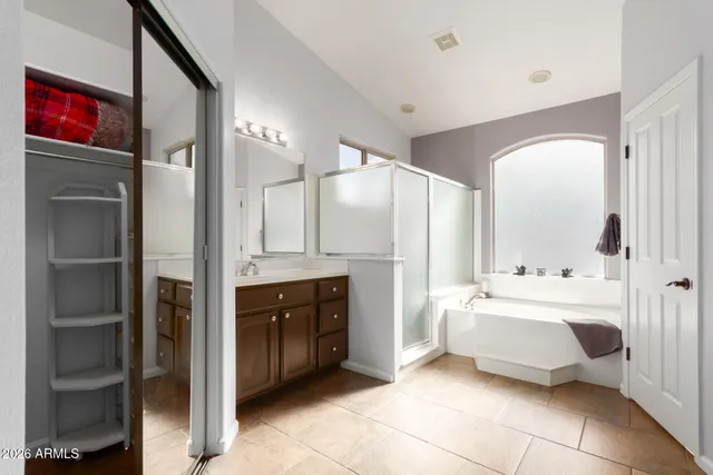 a spacious bathroom with a bathtub sink and mirror