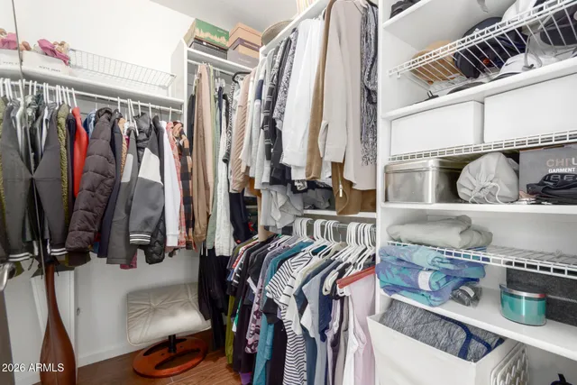 a view of walk in closet with clothes and shoes