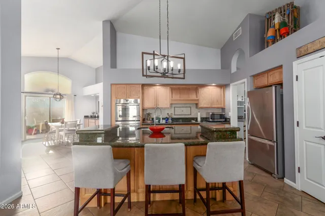 a kitchen with stainless steel appliances a dining table chairs stove refrigerator and microwave