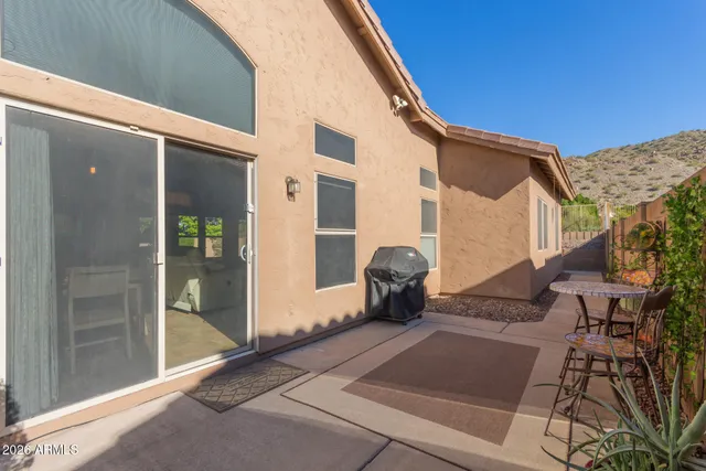 a backyard of a house with table and chairs
