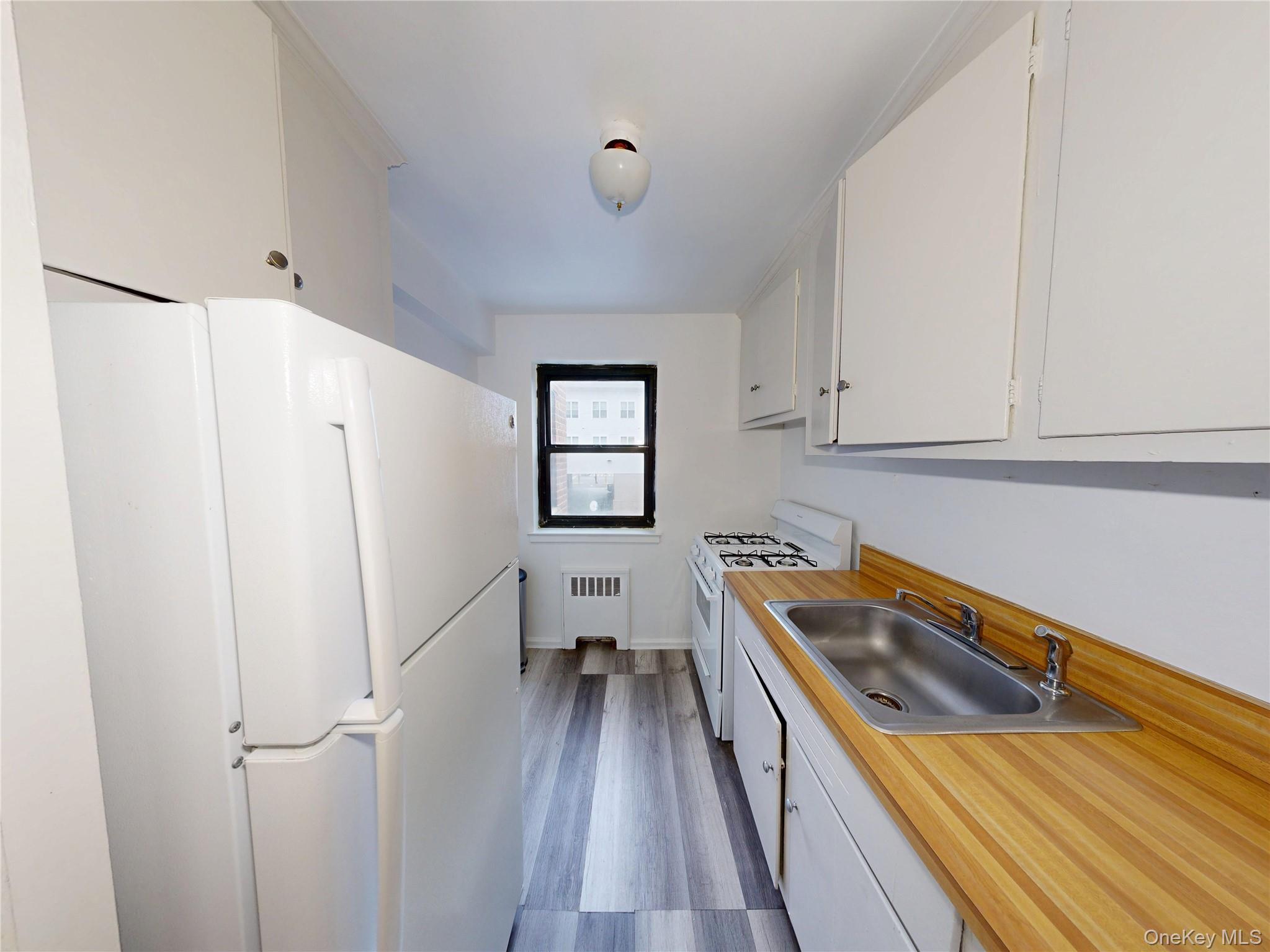 61 White Oak Street, Unit 3A New Rochelle, NY 10801 - Photo 9 of 12 a hallway with white cabinets and wooden floor