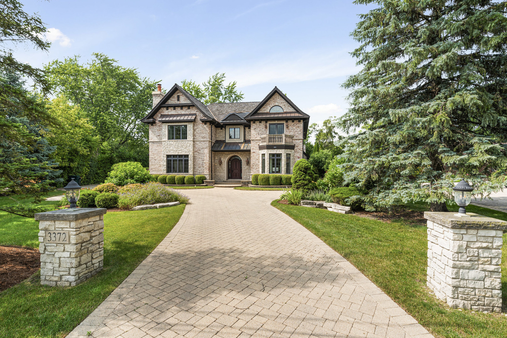 a front view of a house with yard and green space
