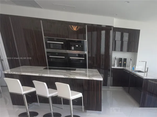 a kitchen with cabinets and chairs