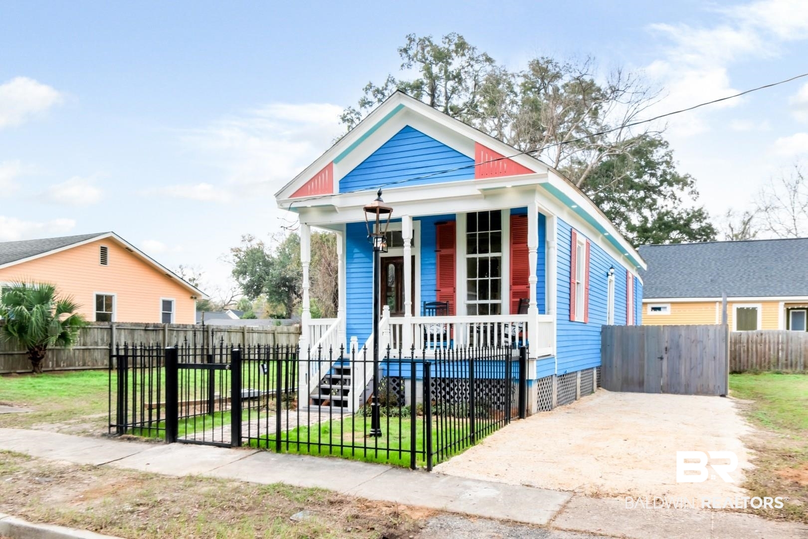 352 Marine Street Mobile, AL 36604 - Photo 19 of 20 Shotgun-style home featuring a porch, a fenced front yard, and driveway