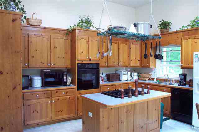 2395 Paddock Wood Road Keswick, VA 22947 - Photo 5 of 5 a kitchen with granite countertop a sink a stove and wooden cabinets