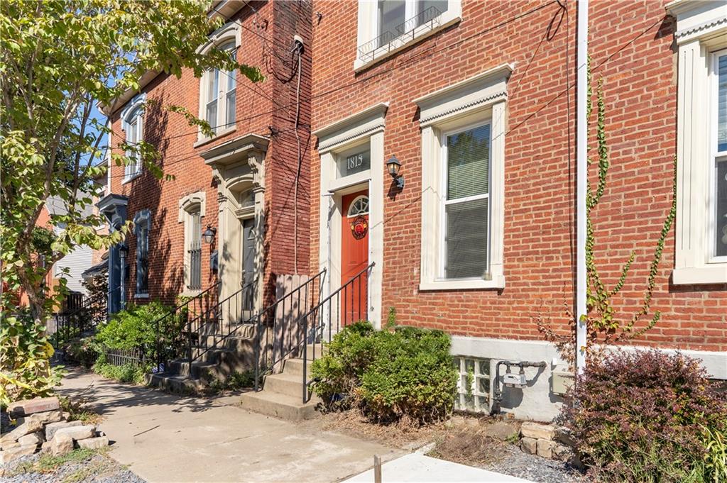1815 Wharton Street Pittsburgh, PA 15203 - Photo 1 of 15 a view of a brick house with a yard and potted plants