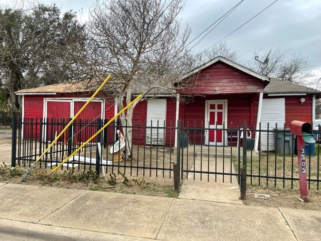a view of house with a small yard and wooden fence