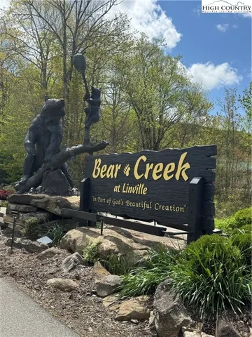 a view of a lake with a yard and large trees