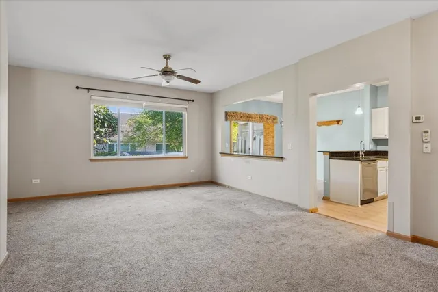 an empty room with a window and a ceiling fan