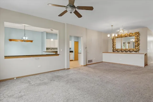 an empty room with windows and chandelier
