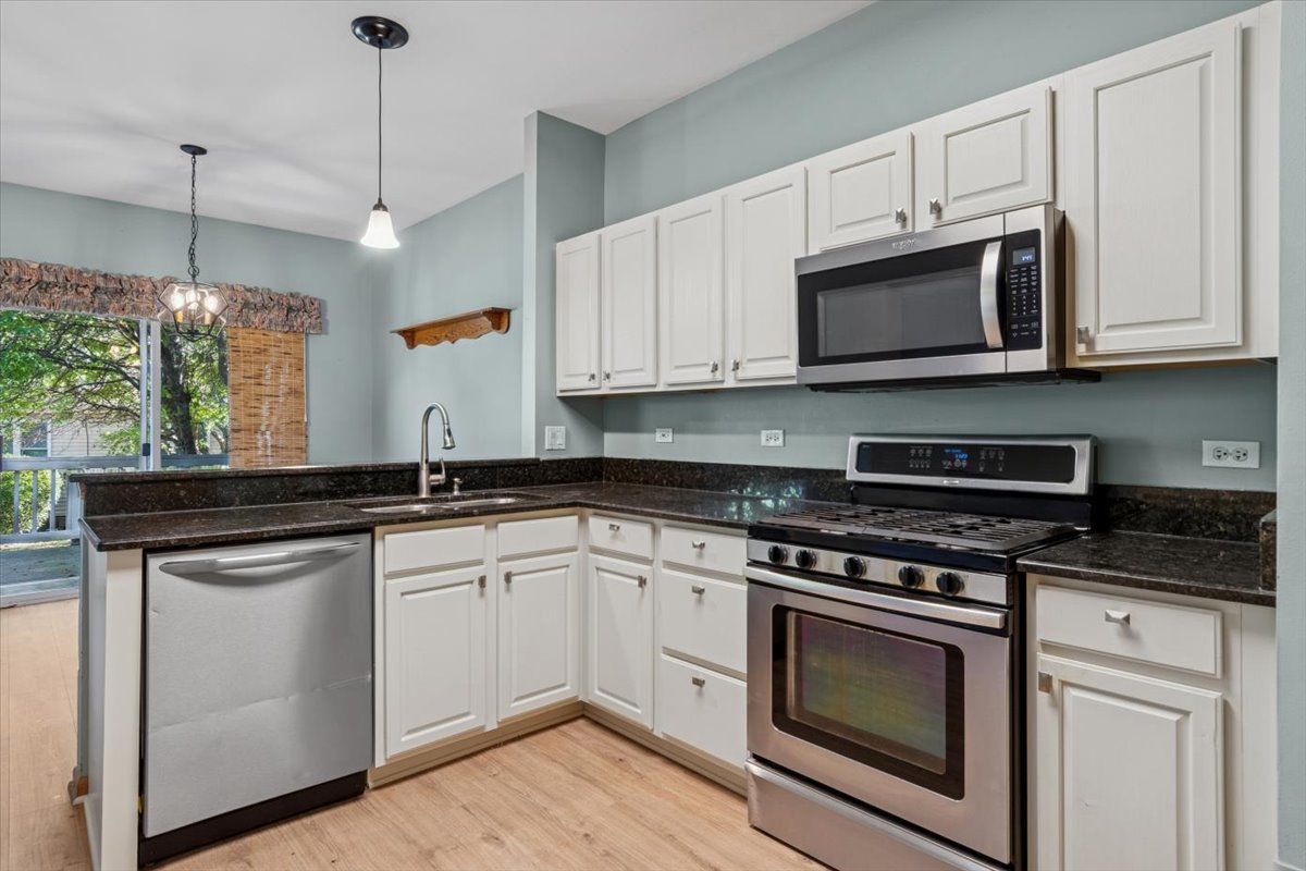 20928 West Spruce Lane Plainfield, IL 60544 - Photo 9 of 20 a kitchen with stainless steel appliances granite countertop a sink a stove a microwave and wooden cabinets