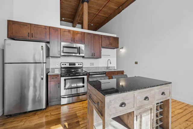 a kitchen with stainless steel appliances a refrigerator and a stove top oven