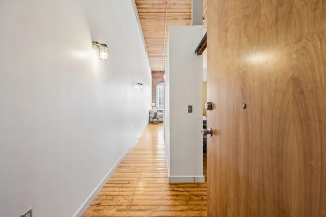 a view of a hallway with wooden floor and staircase