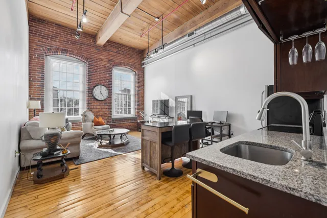 a kitchen with a sink dishwasher a stove and cabinets with wooden floor