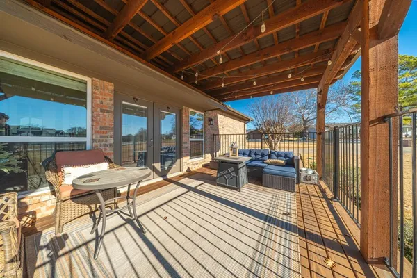 a view of a patio with dining table and chairs with wooden floor