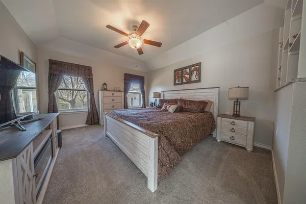 a spacious bedroom with a bed and a flat screen tv