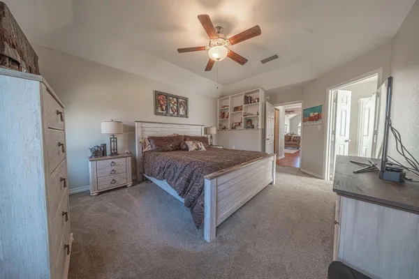 a spacious bedroom with a bed and a flat screen tv