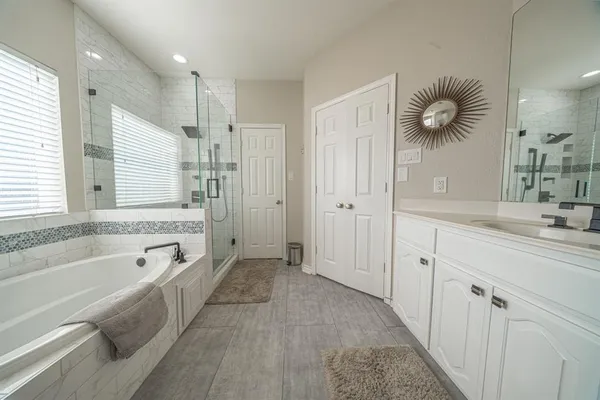 a bathroom with a tub sink and mirror