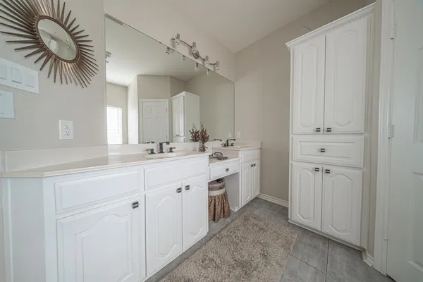 a spacious bathroom with a double vanity sink a mirror and a shower