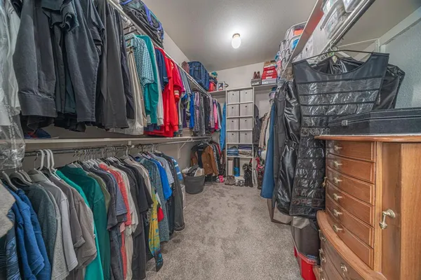 a view of walk in closet with clothes and shoes