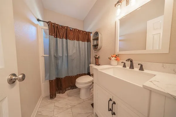 a bathroom with a sink a toilet and shower