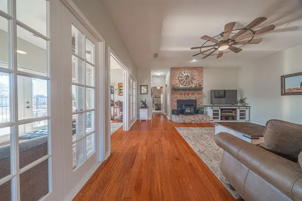 a large living room with stainless steel appliances granite countertop furniture a fireplace and a flat screen tv