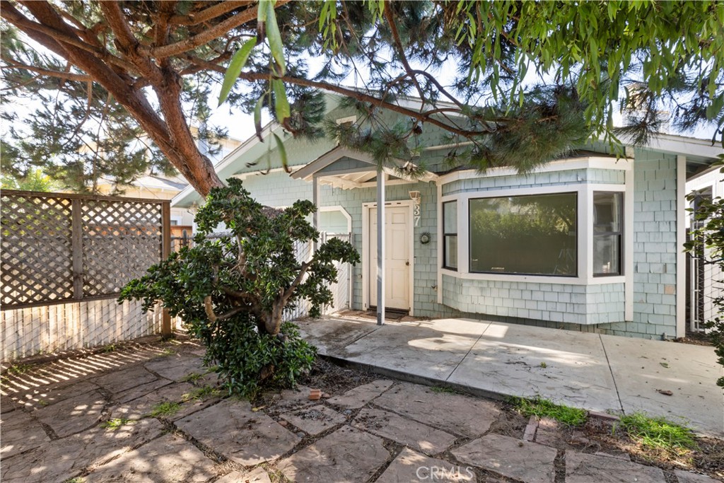 a front view of a house with a yard and potted plants