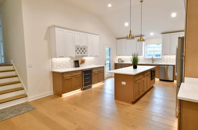 a large kitchen with kitchen island a sink a counter top space stainless steel appliances and a window